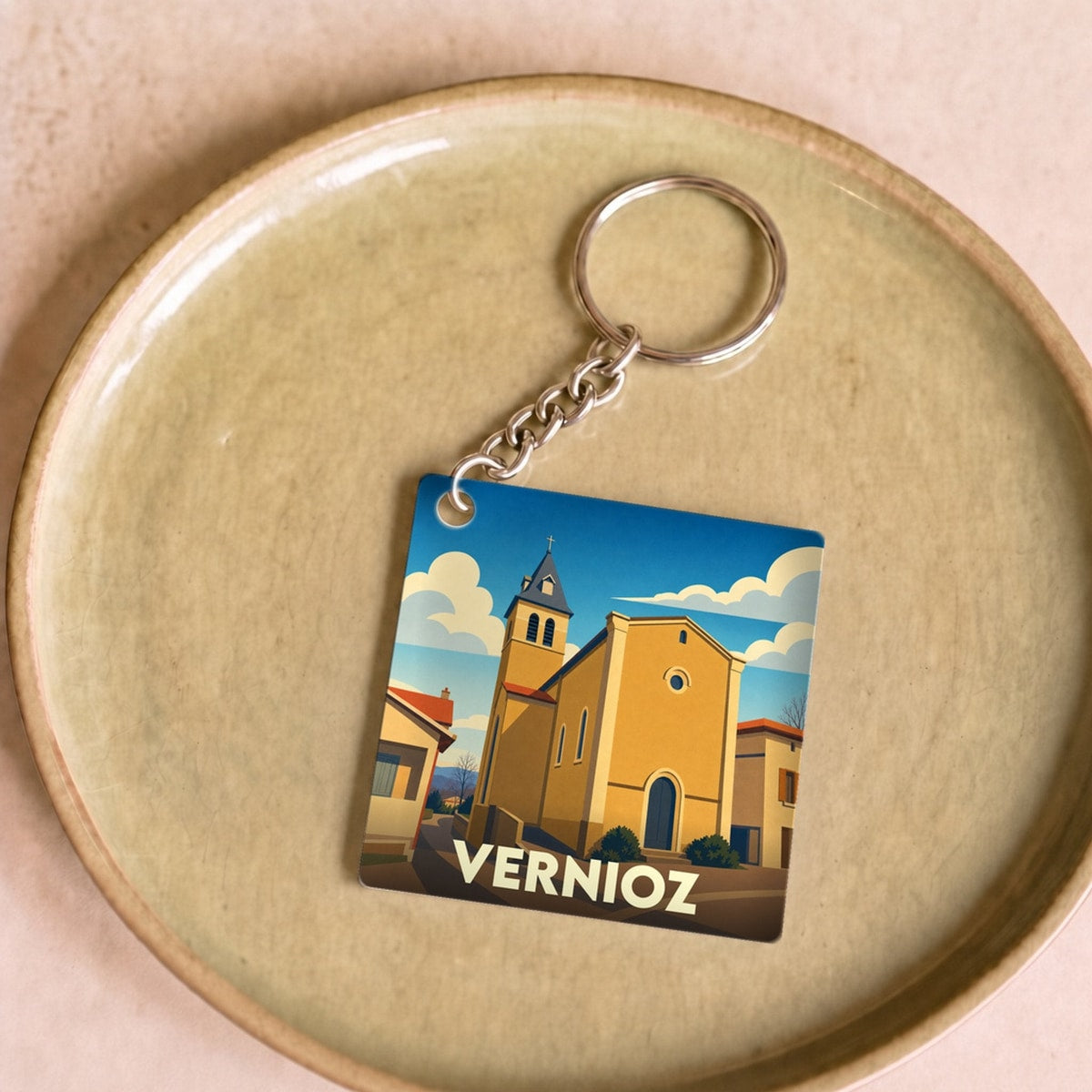 Porte-clés souvenir de la ville de Vernioz avec une illustration stylisée de son église.