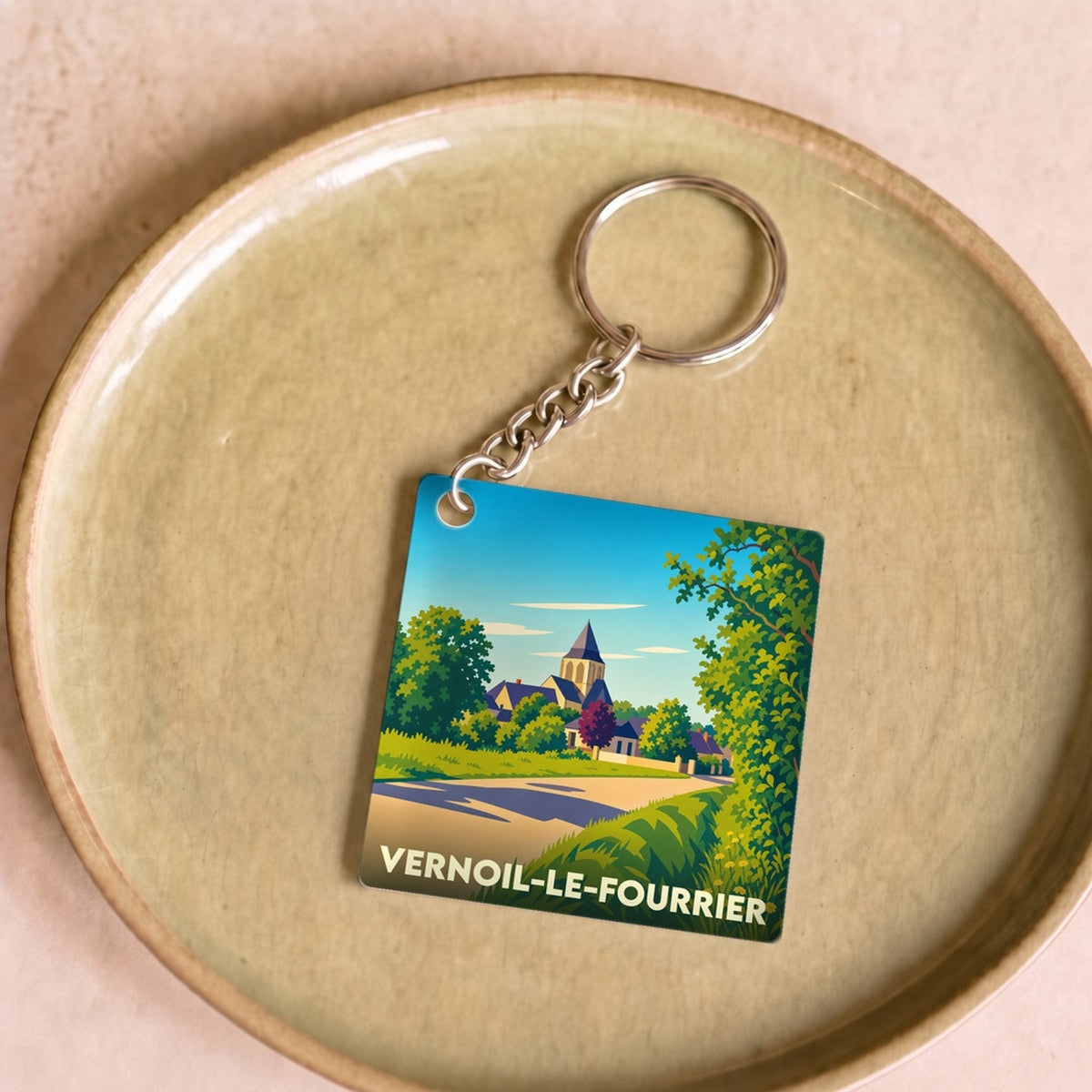 Porte-clés souvenir de la ville de Vernoil-le-Fourrier avec une illustration stylisée de son paysage.