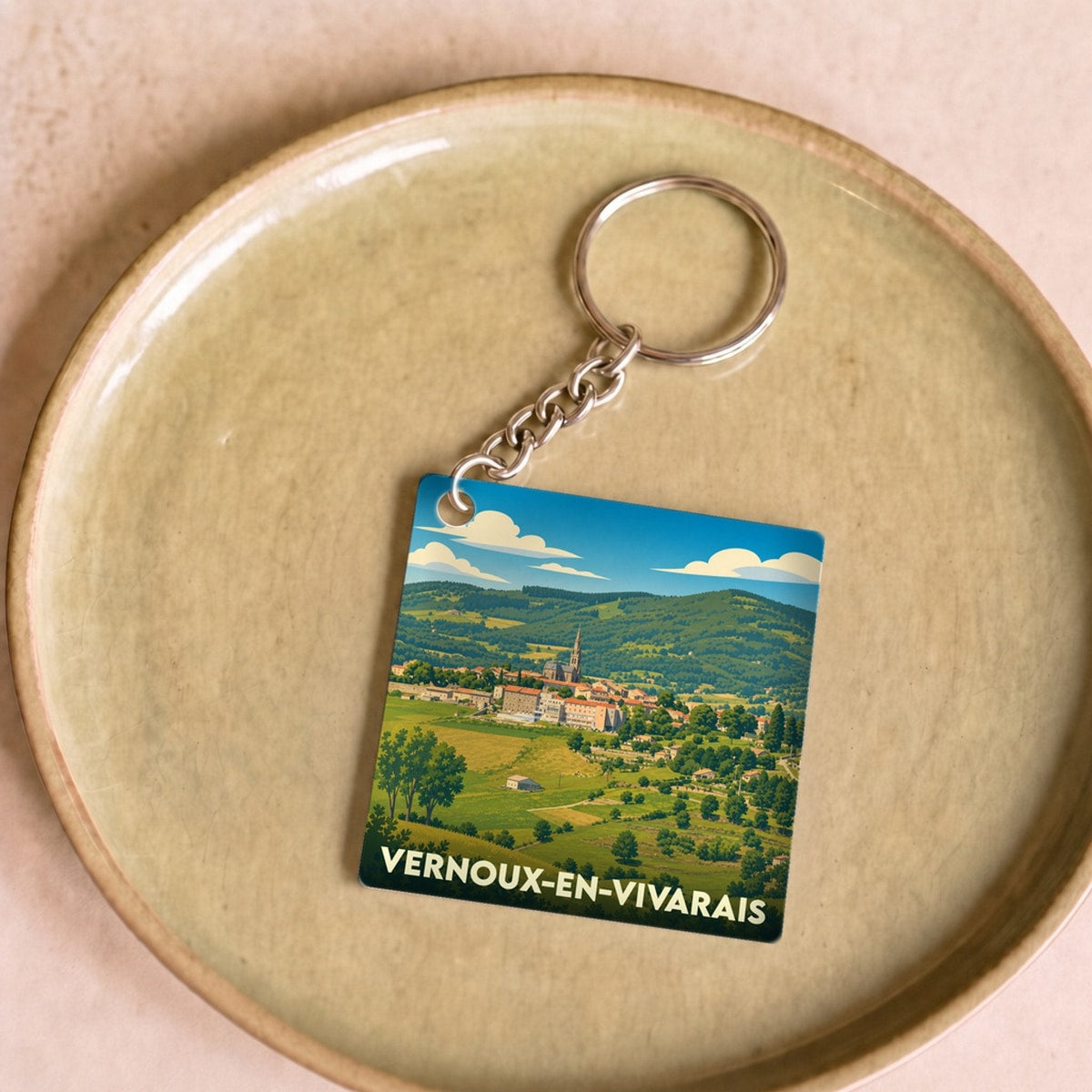 Porte-clés souvenir de la ville de Vernoux-en-Vivarais avec une illustration paysagère stylisée.