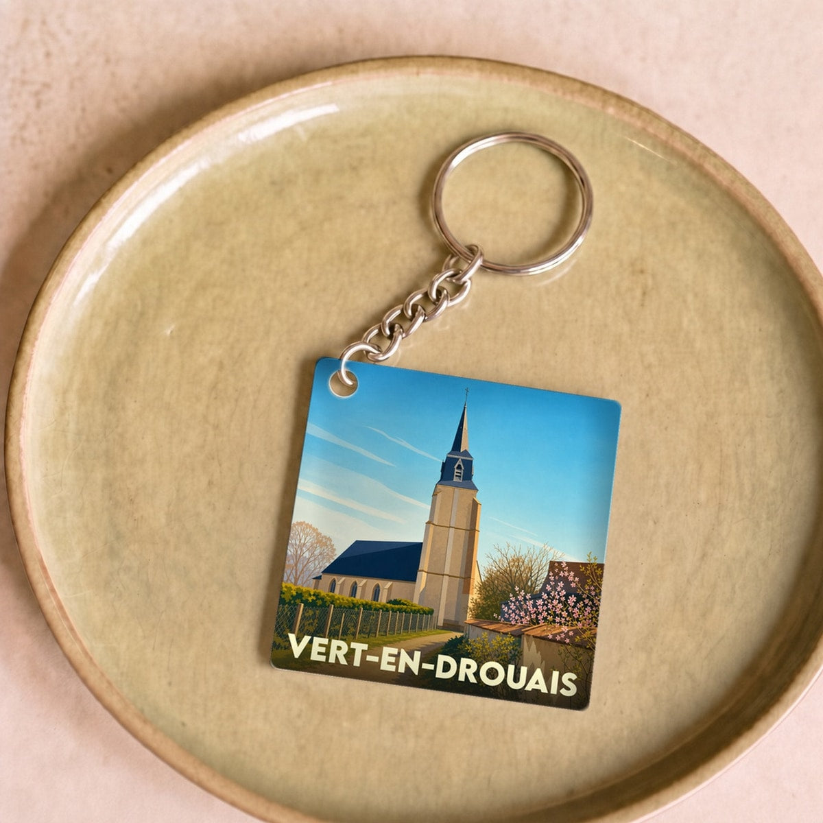 Porte-clés souvenir de la ville de Vert-en-Drouais avec une illustration stylisée de son église.