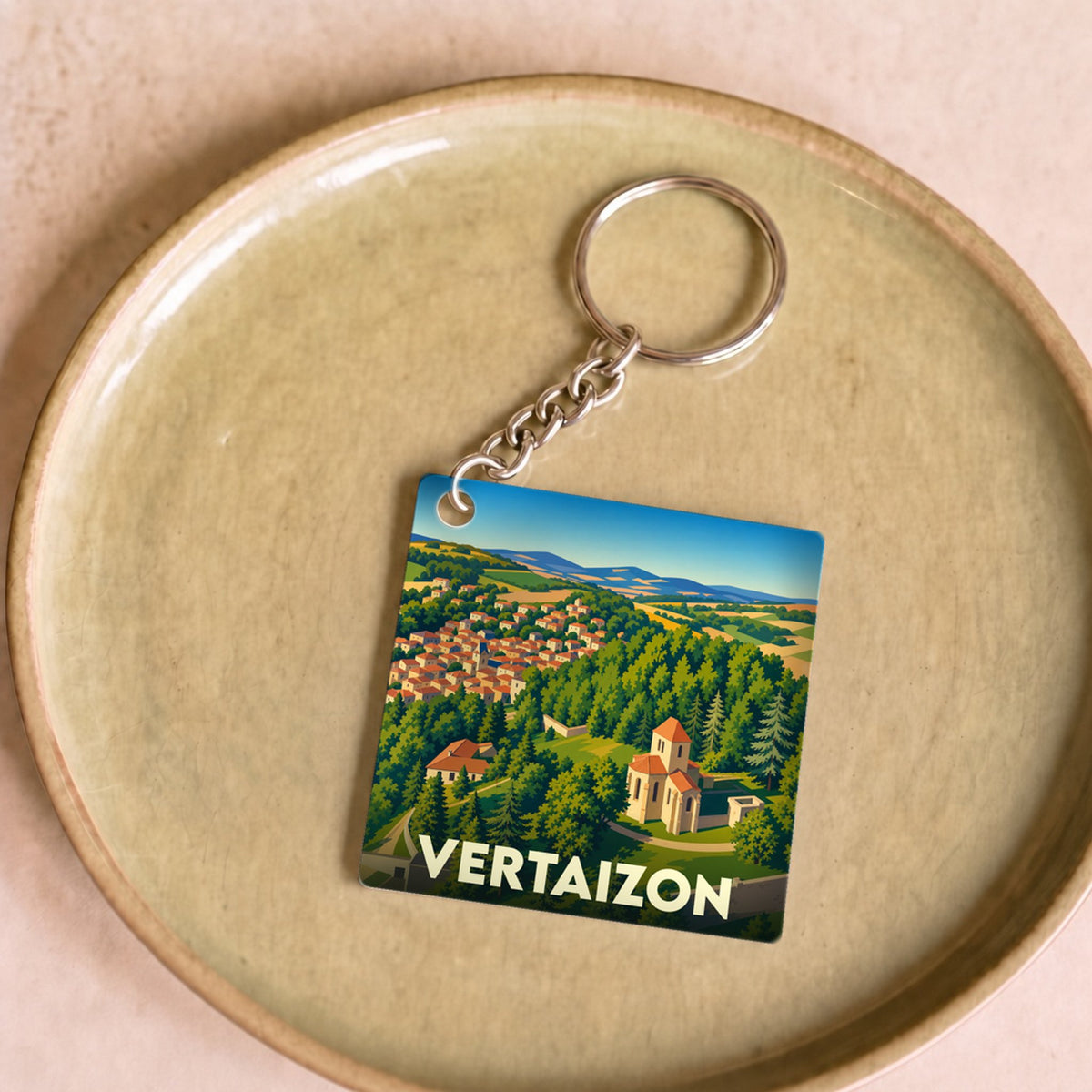 Porte-clés souvenir de la ville de Vertaizon avec une illustration stylisée de son paysage et de ses monuments.