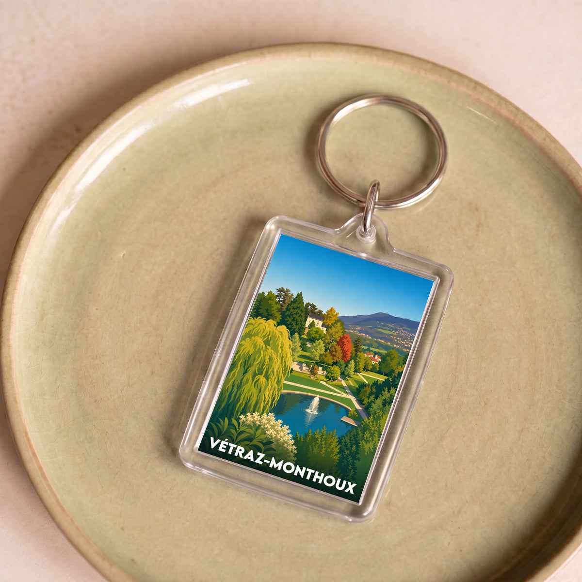 Porte-clés souvenir de la ville de Vétraz-Monthoux avec une illustration stylisée de son paysage.
