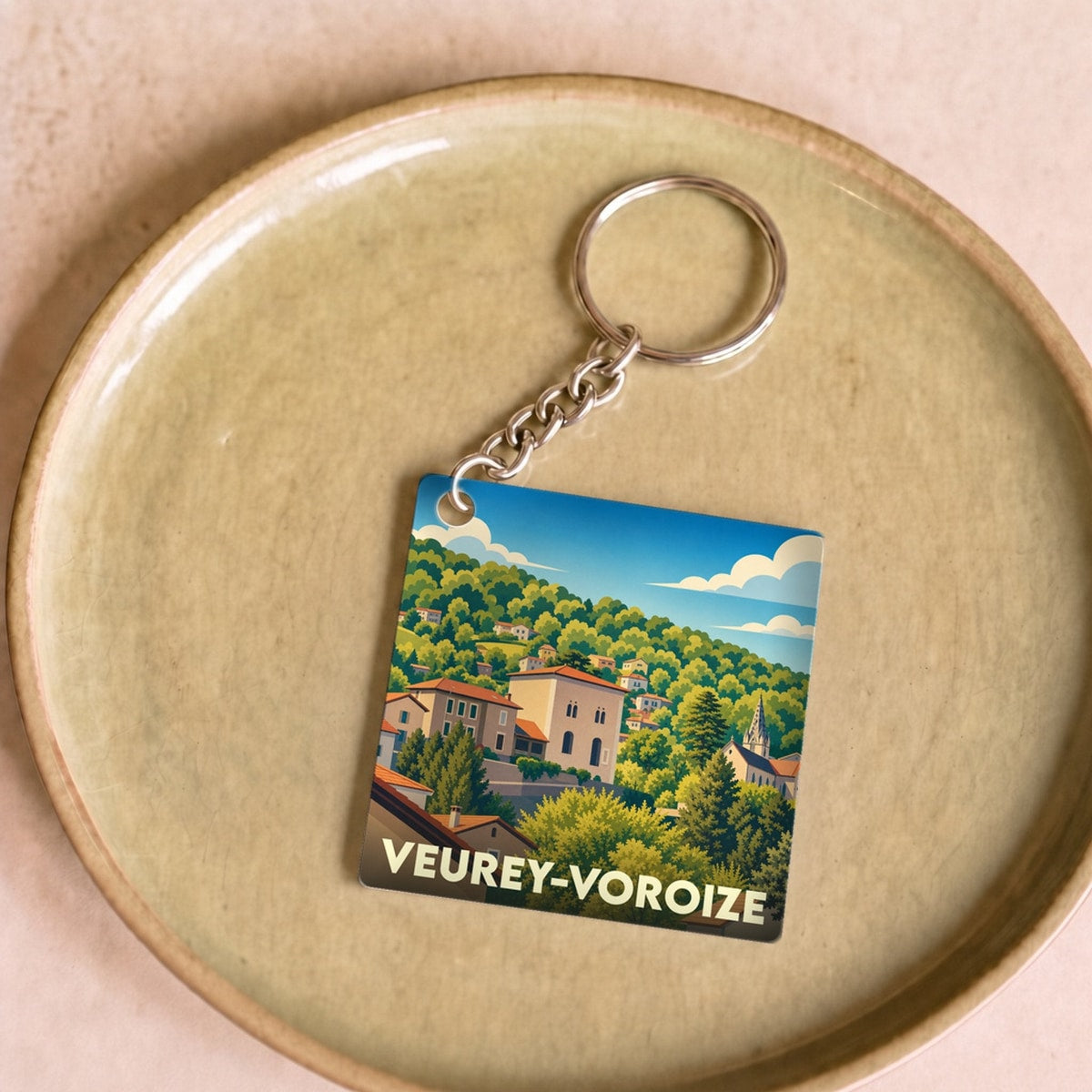 Porte-clés souvenir de la ville de Veurey-Voroize avec une illustration stylisée.