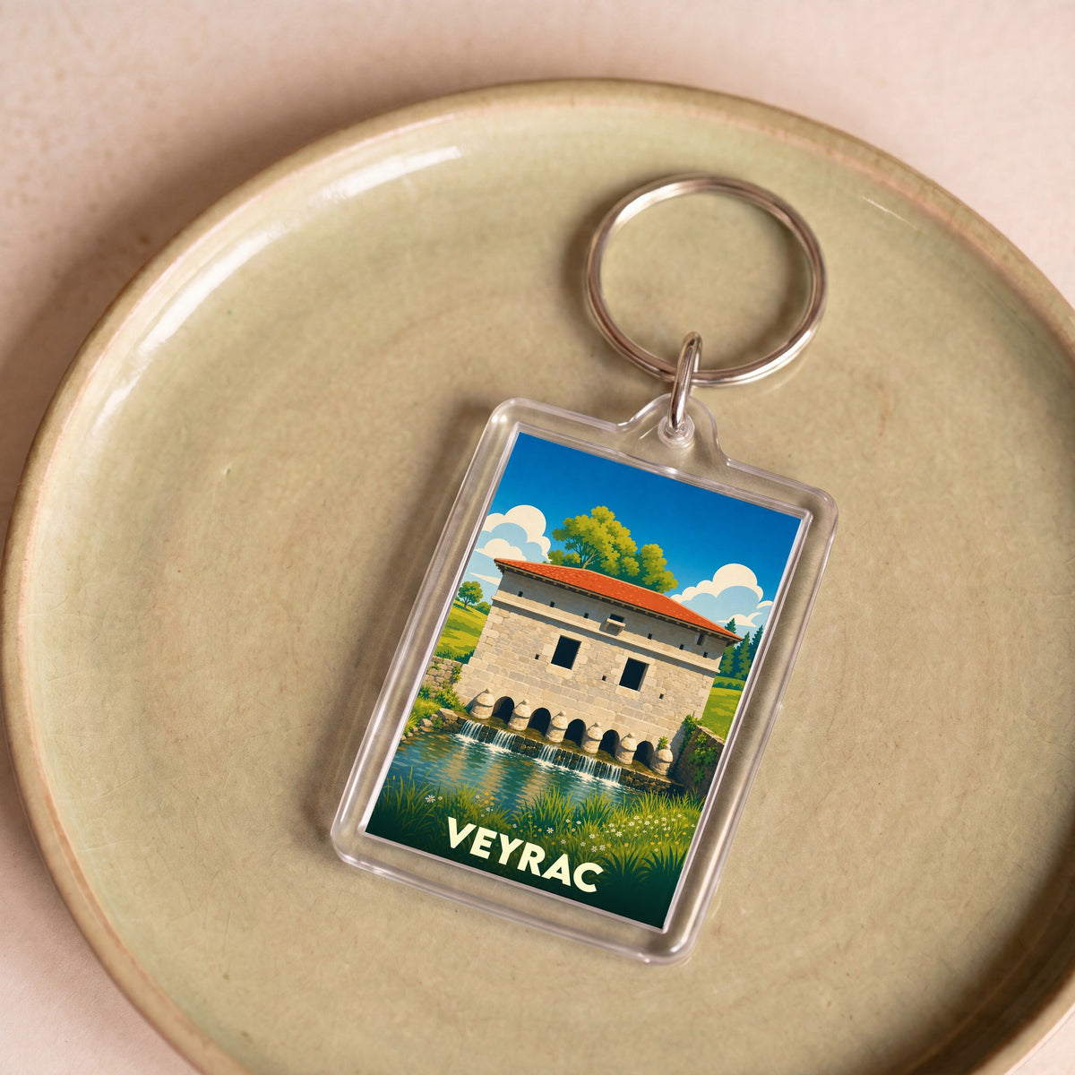 Porte-clés souvenir de la ville de Veyrac avec une illustration stylisée de son moulin.