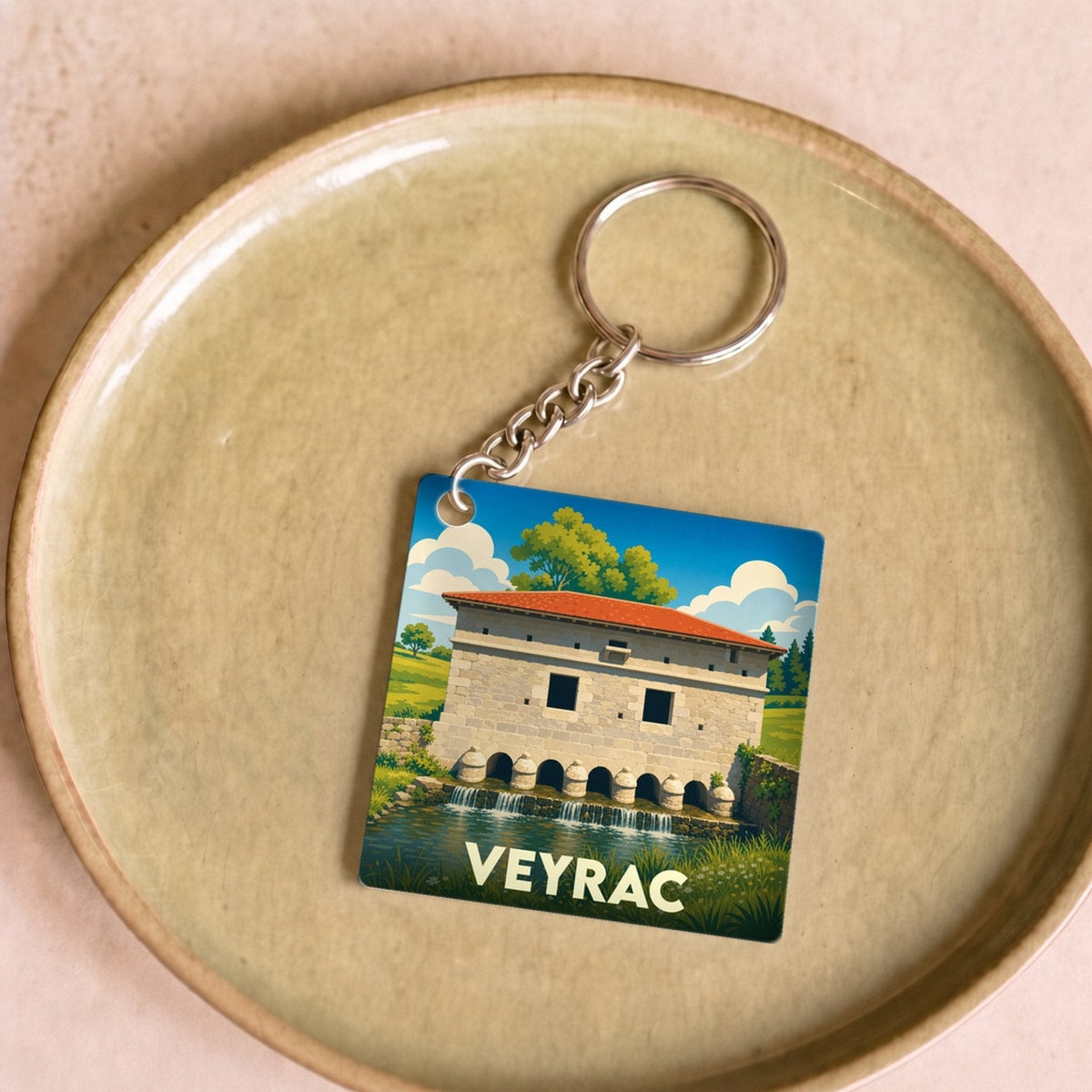 Porte-clés souvenir de la ville de Veyrac avec une illustration stylisée de son moulin.