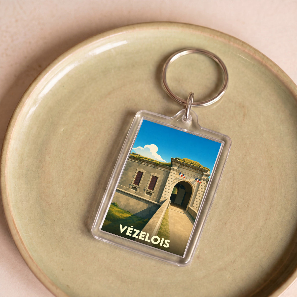 Porte-clés souvenir de la ville de Vézelois avec une illustration stylisée de son fort.