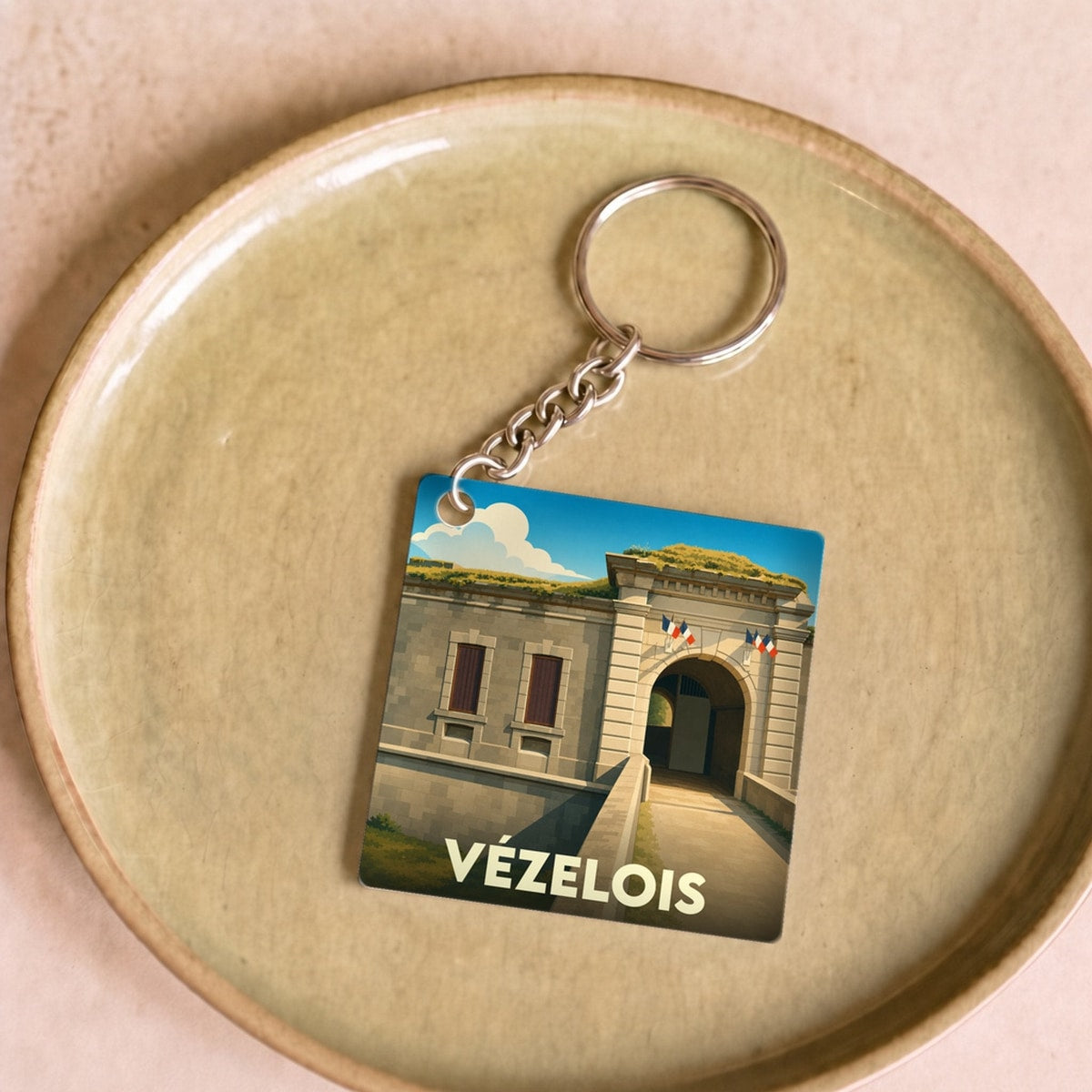 Porte-clés souvenir de la ville de Vézelois avec une illustration stylisée de son fort.