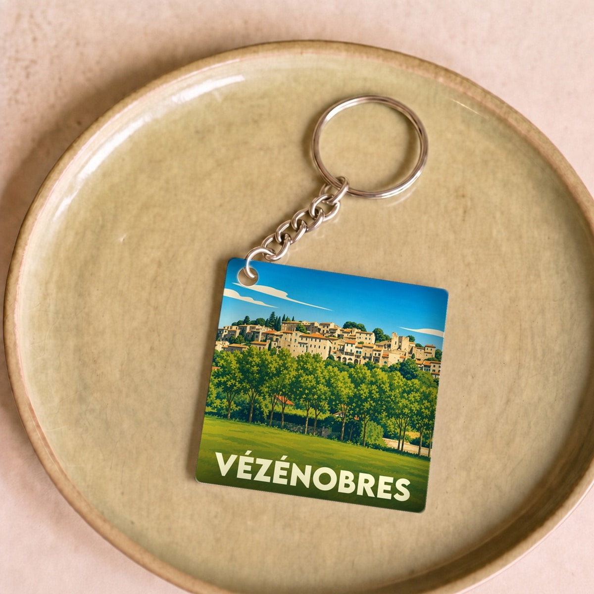 Porte-clés souvenir de la ville de Vézénobres avec une illustration stylisée.