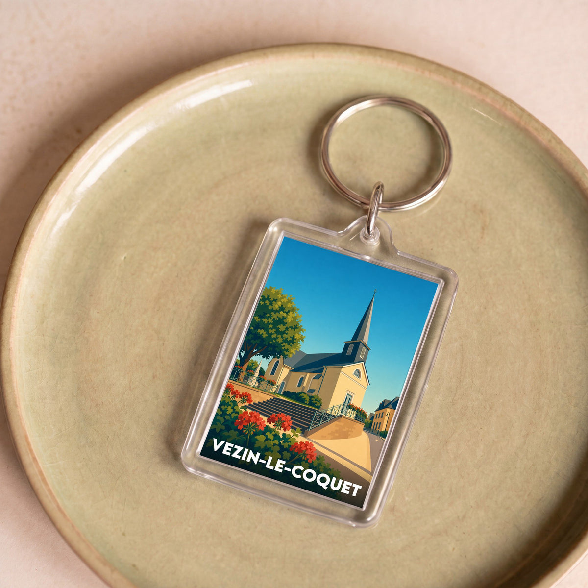 Porte-clés souvenir de la ville de Vezin-le-Coquet avec une illustration stylisée de son église.