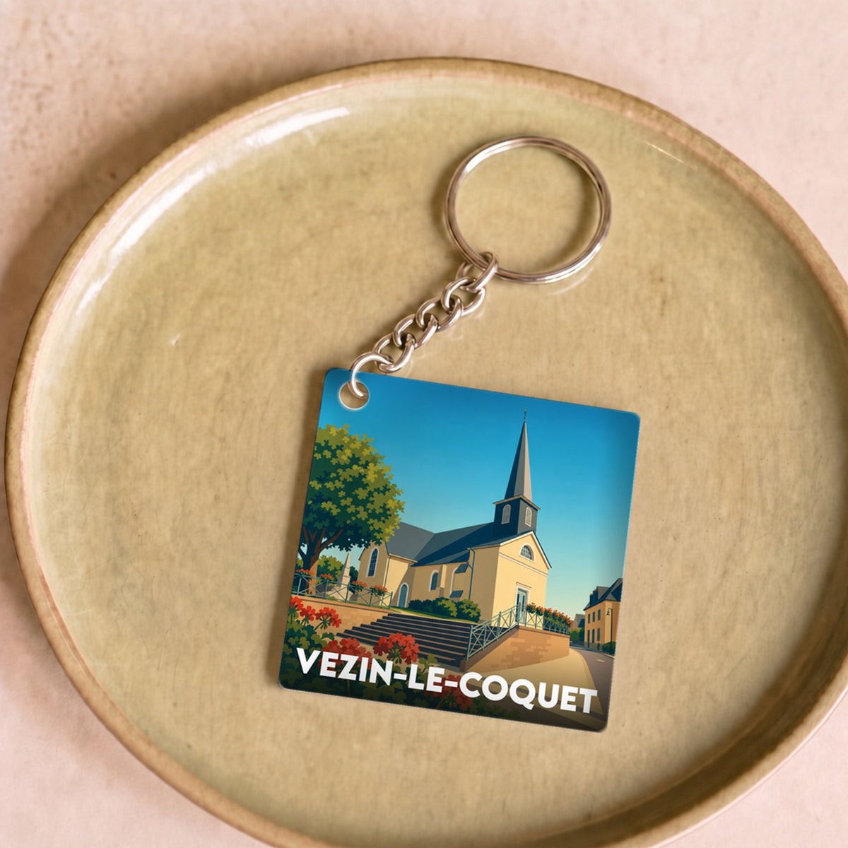 Porte-clés souvenir de la ville de Vezin-le-Coquet avec une illustration stylisée de son église.