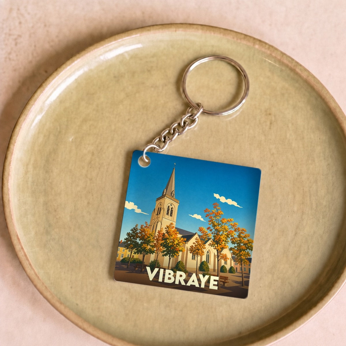 Porte-clés souvenir de la ville de Vibraye avec une illustration stylisée de son église.