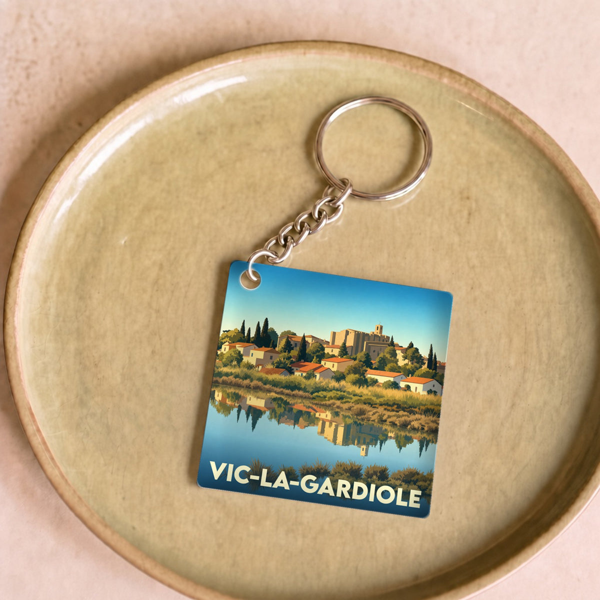 Porte-clés souvenir de la ville de Vic-la-Gardiole avec une illustration stylisée.