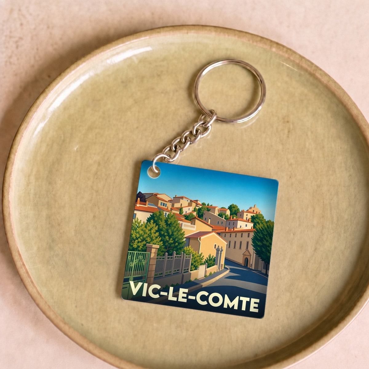 Porte-clés souvenir de la ville de Vic-le-Comte avec une illustration stylisée.