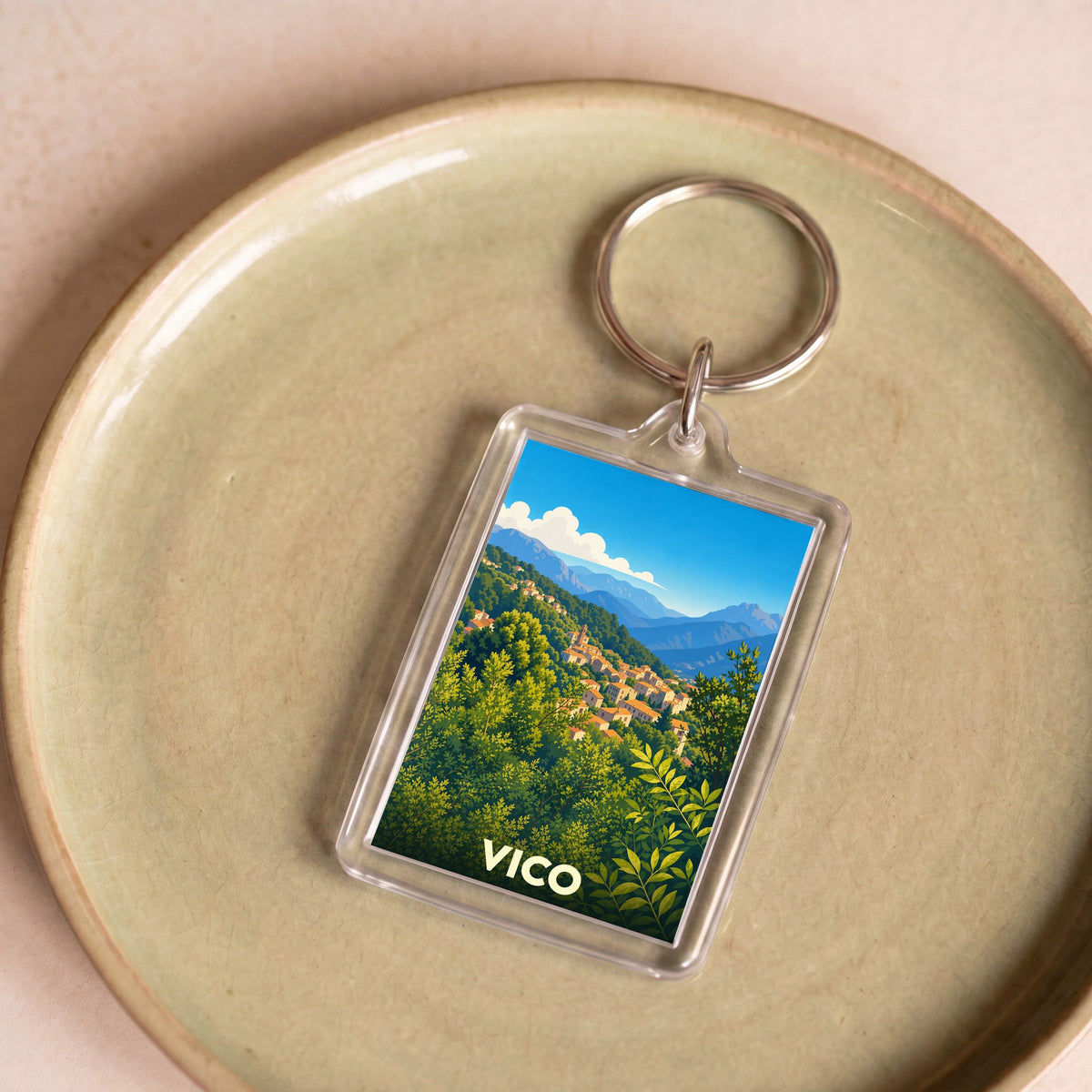 Porte-clés souvenir de la ville de Vico avec une illustration stylisée de son paysage montagneux.
