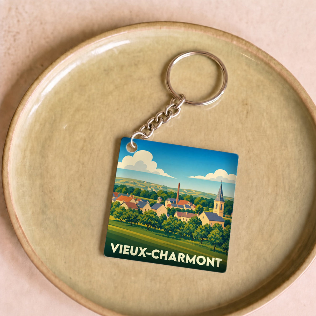 Porte-clés souvenir de la ville de Vieux-Charmont avec une illustration stylisée.