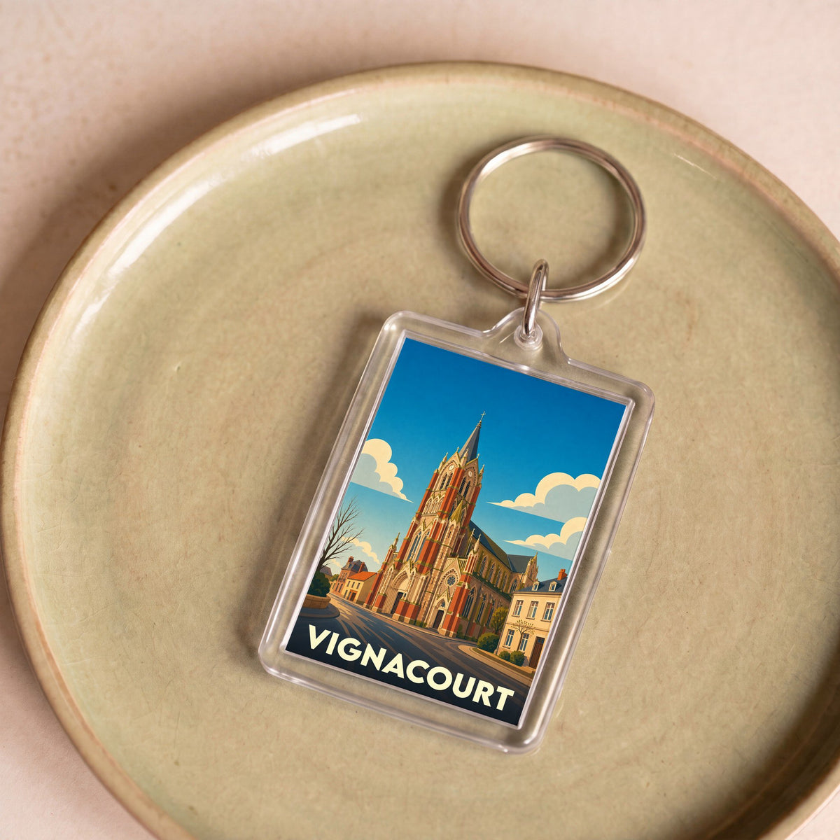 Porte-clés souvenir de la ville de Vignacourt avec une illustration stylisée de son église.