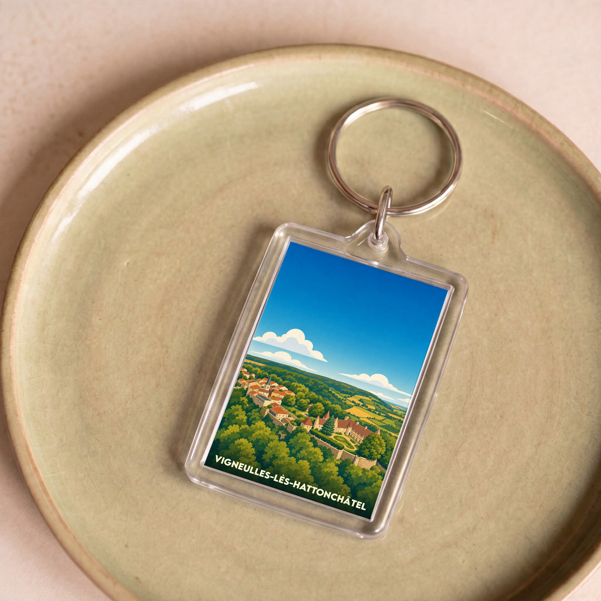 Porte-clés souvenir de Vigneulles-lès-Hattonchâtel avec une illustration stylisée du village et de son paysage.