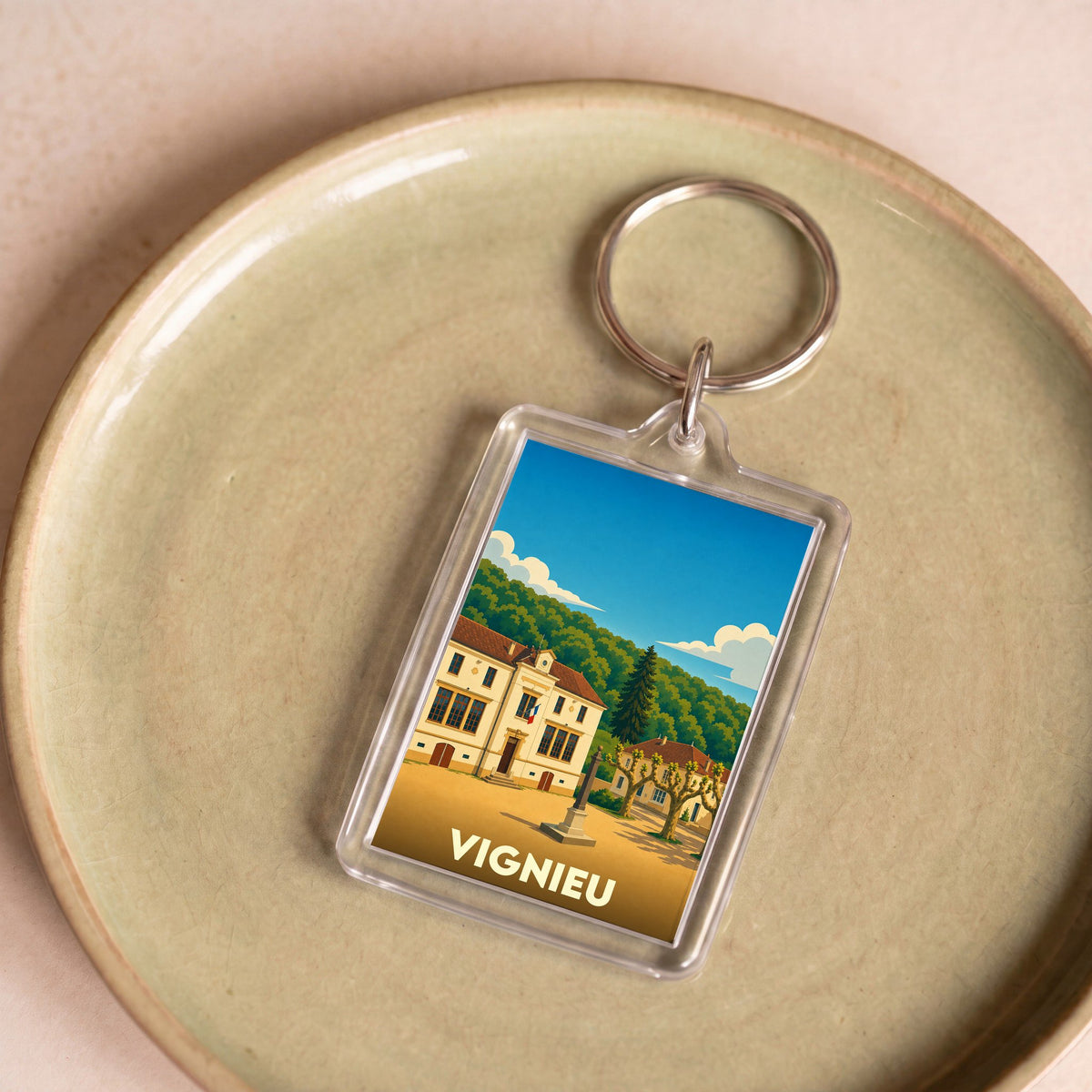 Porte-clés souvenir de la ville de Vignieu avec une illustration stylisée.
