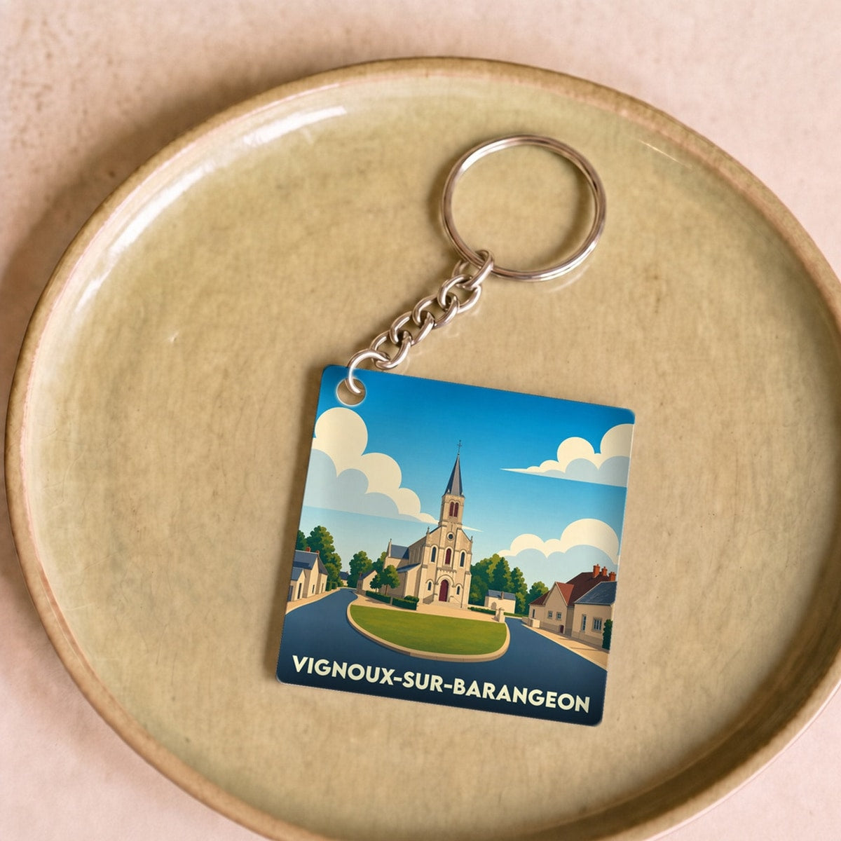 Porte-clés souvenir de la ville de Vignoux-sur-Barangeon avec une illustration stylisée de son église.
