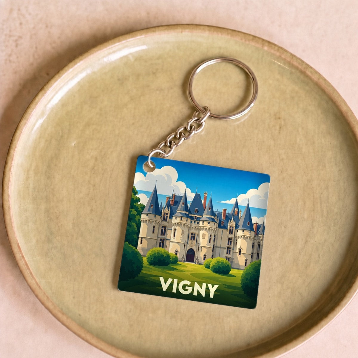 Porte-clés souvenir de la ville de Vigny illustrant son château dans un style graphique épuré.