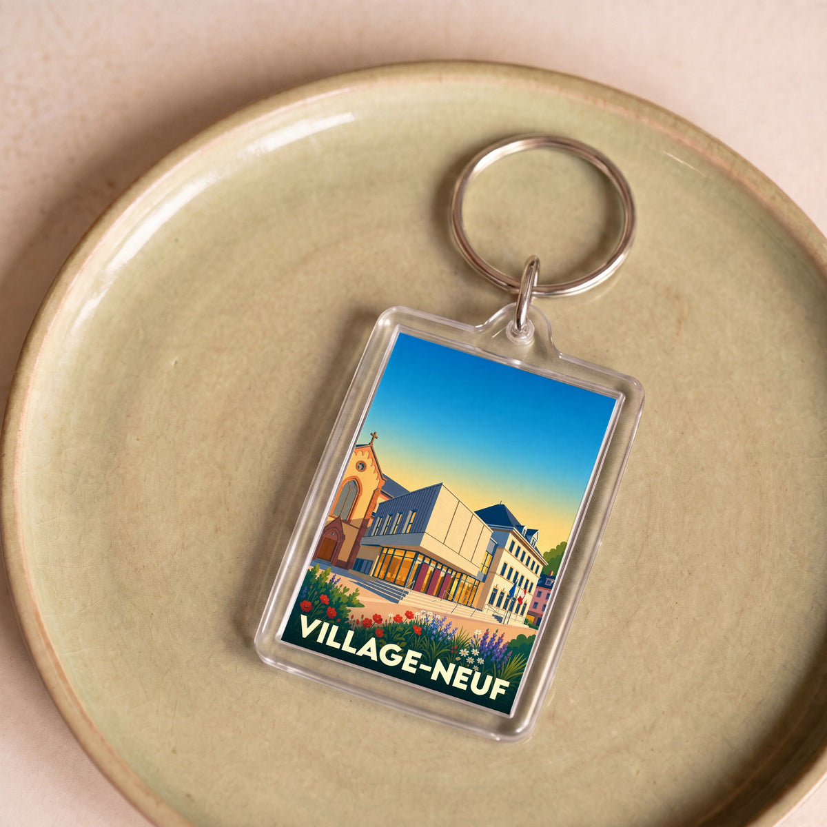Porte-clés souvenir de la ville de Village-Neuf avec une illustration stylisée.