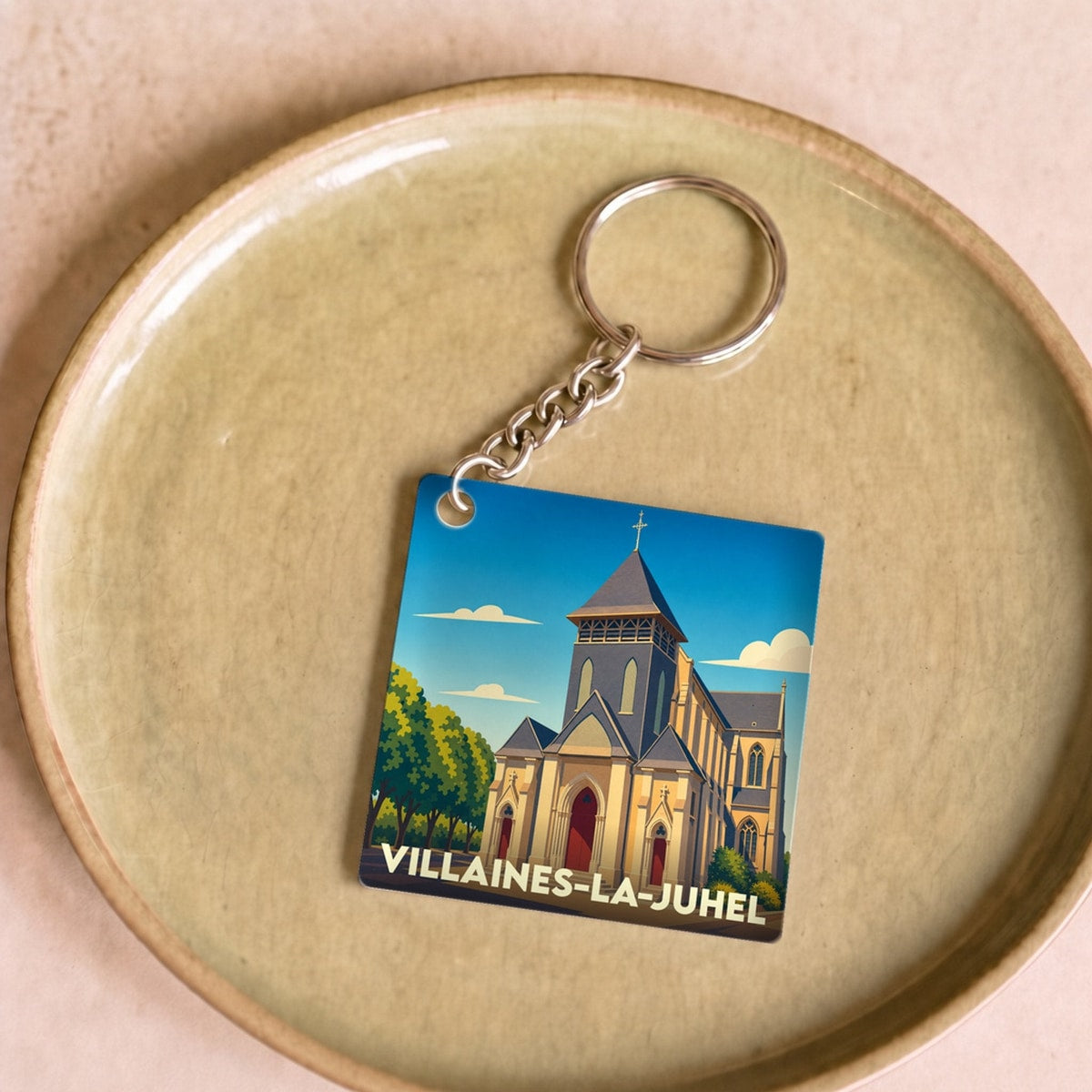 Porte-clés souvenir de la ville de Villaines-la-Juhel avec une illustration stylisée de son église.