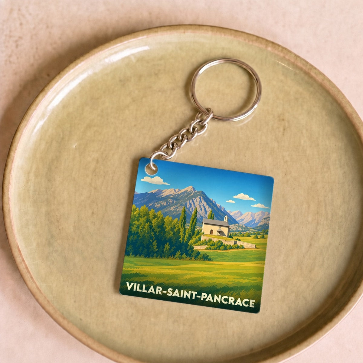 Porte-clés souvenir de la ville de Villar-Saint-Pancrace avec une illustration stylisée d'un paysage montagneux.