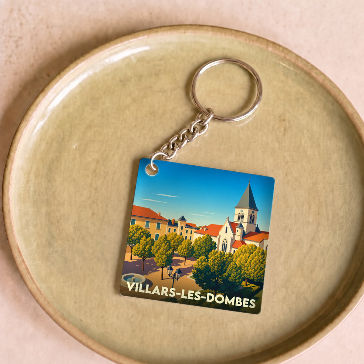 Porte-clés souvenir de la ville de Villars-les-Dombes avec une illustration stylisée.