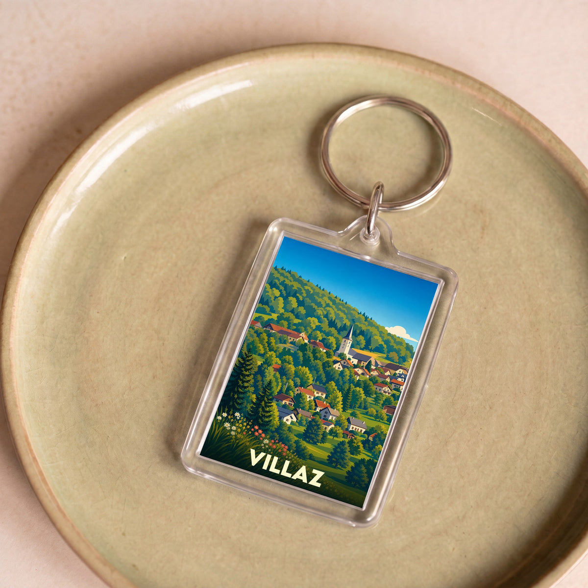 Porte-clés souvenir de la ville de Villaz avec une illustration stylisée de son village et de ses montagnes.