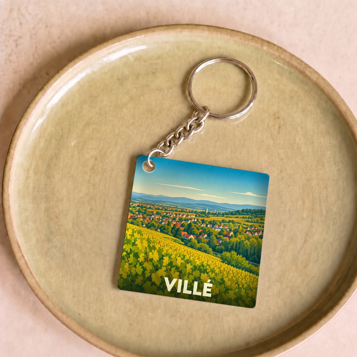 Porte-clés souvenir de la ville de Villé avec une illustration stylisée de vignobles ensoleillés.