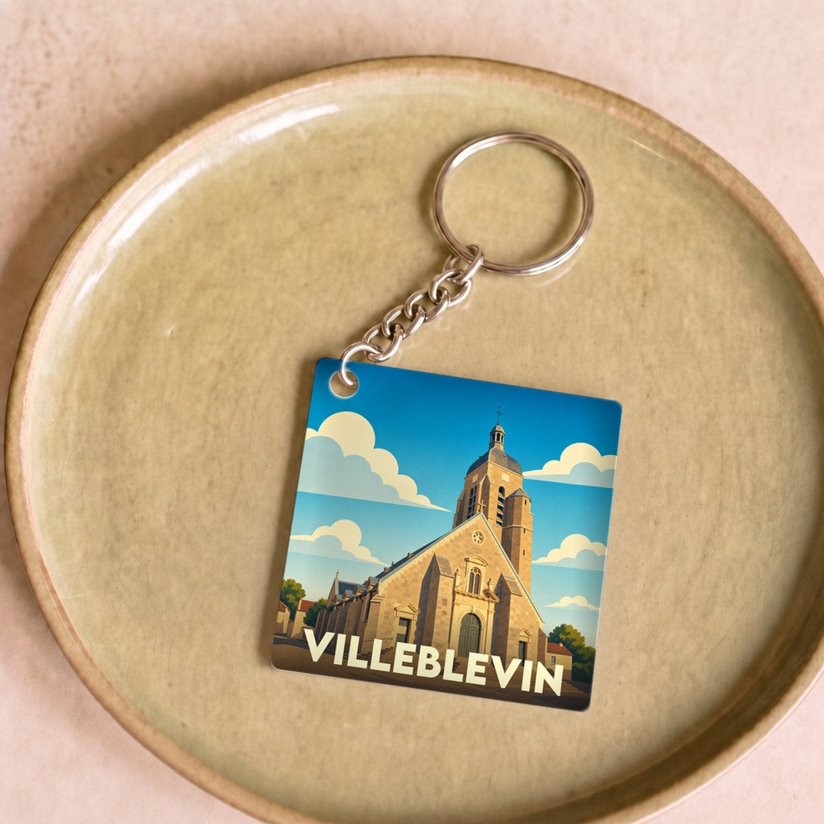 Porte-clés souvenir de la ville de Villeblevin avec une illustration stylisée de son église.
