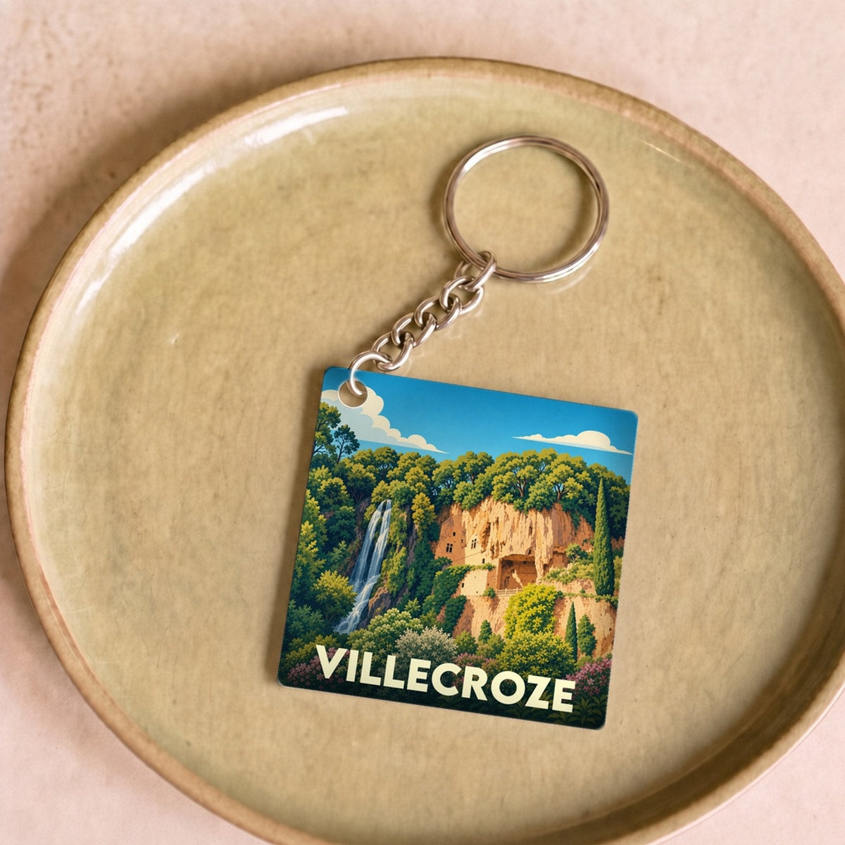 Porte-clés souvenir de la ville de Villecroze avec une illustration stylisée d'une cascade et de grottes troglodytiques.