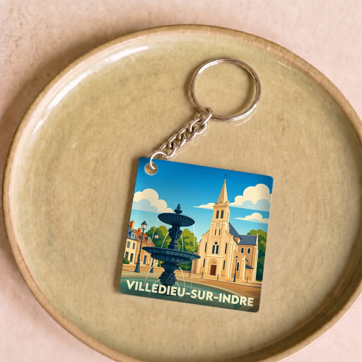 Porte-clés souvenir de la ville de Villedieu-sur-Indre avec une illustration stylisée.