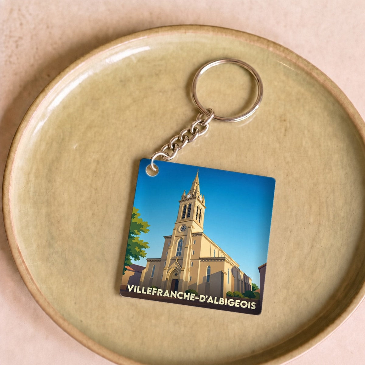 Porte-clés souvenir de la ville de Villefranche-d'Albigeois avec une illustration stylisée de son église.