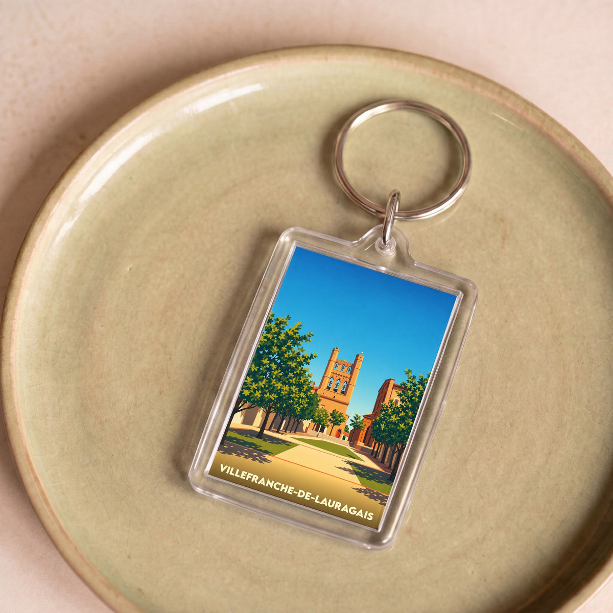 Porte-clés souvenir de la ville de Villefranche-de-Lauragais avec une illustration stylisée.