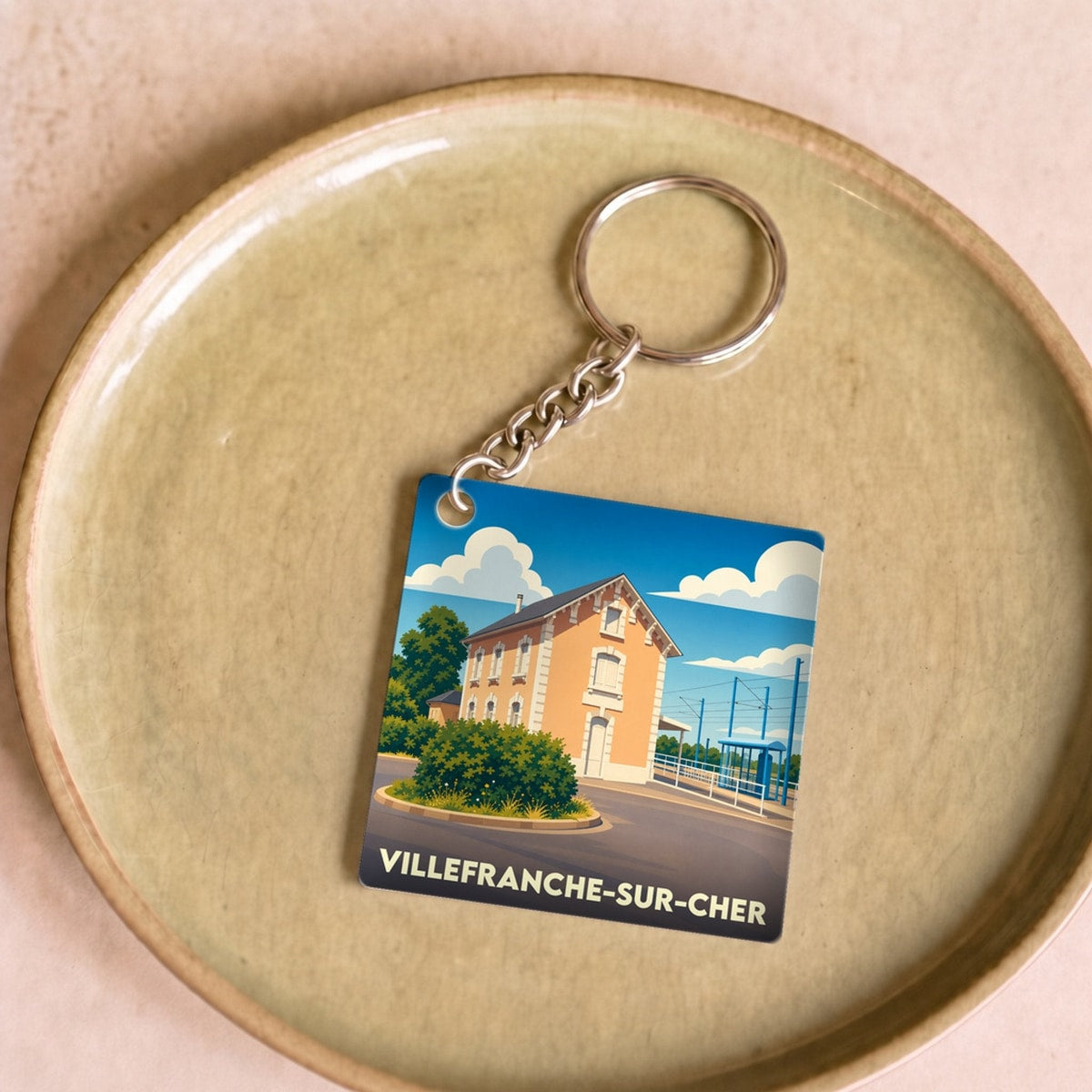 Porte-clés souvenir de la ville de Villefranche-sur-Cher avec une illustration stylisée de sa gare.