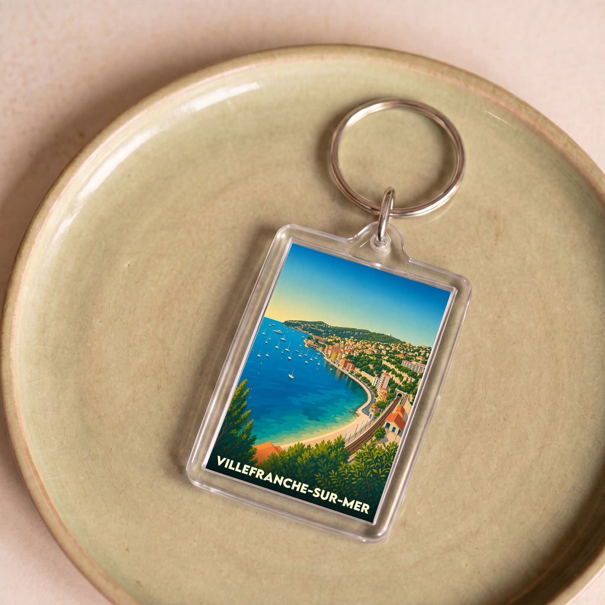 Porte-clés souvenir de la ville de Villefranche-sur-Mer avec une illustration stylisée de sa baie.