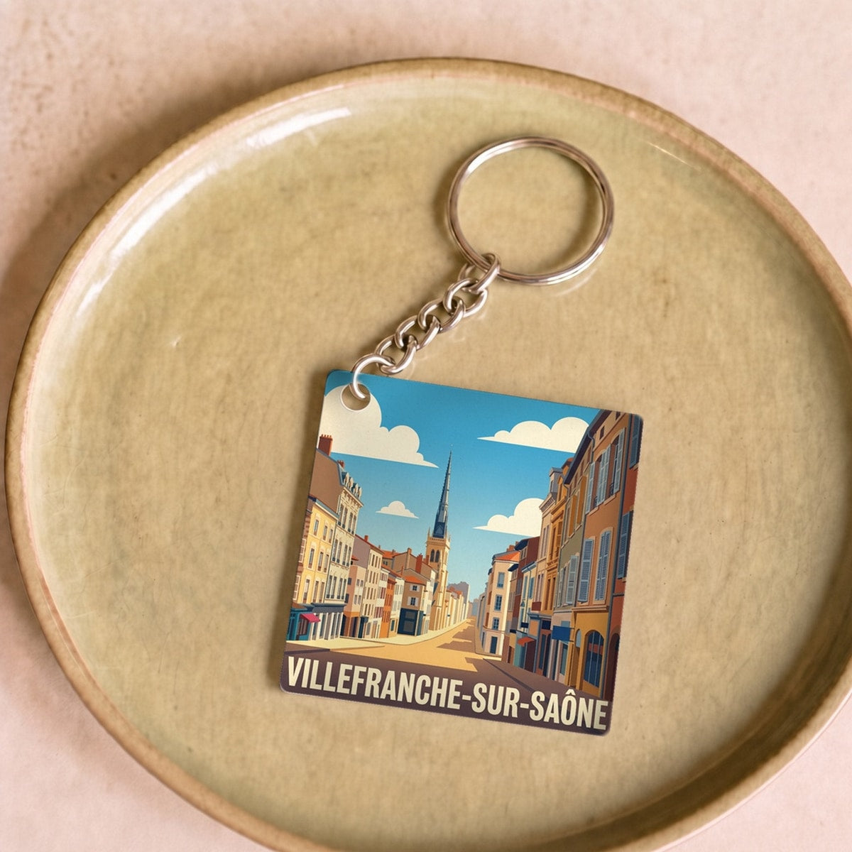 Porte-clés souvenir de la ville de Villefranche-sur-Saône avec une illustration stylisée.