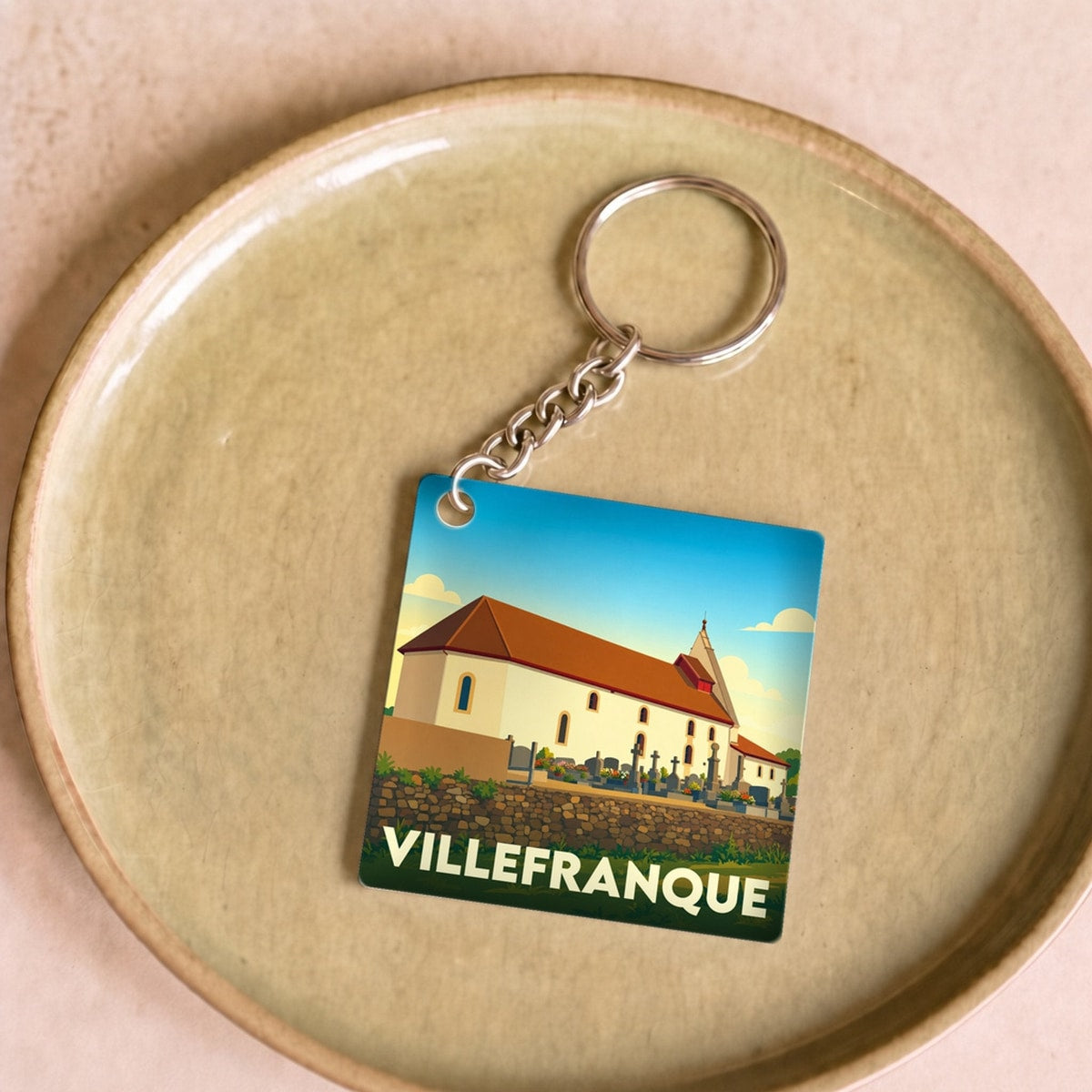 Porte-clés souvenir de la ville de Villefranque avec une illustration stylisée.