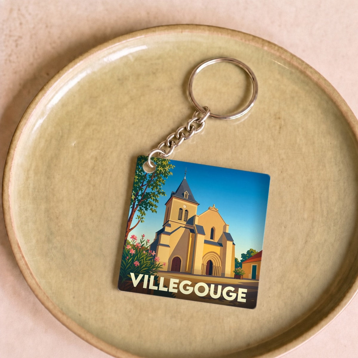 Porte-clés souvenir de la ville de Villegouge avec une illustration stylisée de son église.