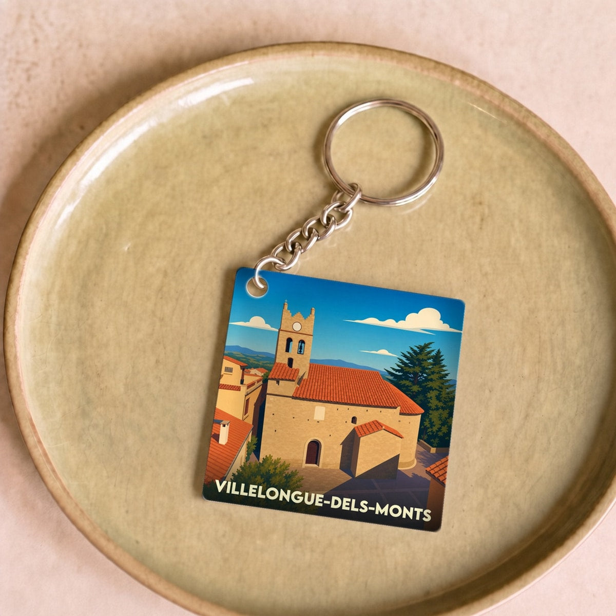 Porte-clés souvenir de la ville de Villelongue-dels-Monts avec une illustration stylisée de son église.