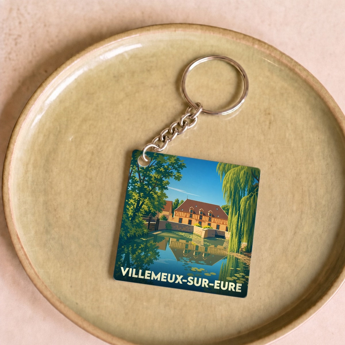 Porte-clés souvenir de la ville de Villemeux-sur-Eure avec une illustration stylisée.