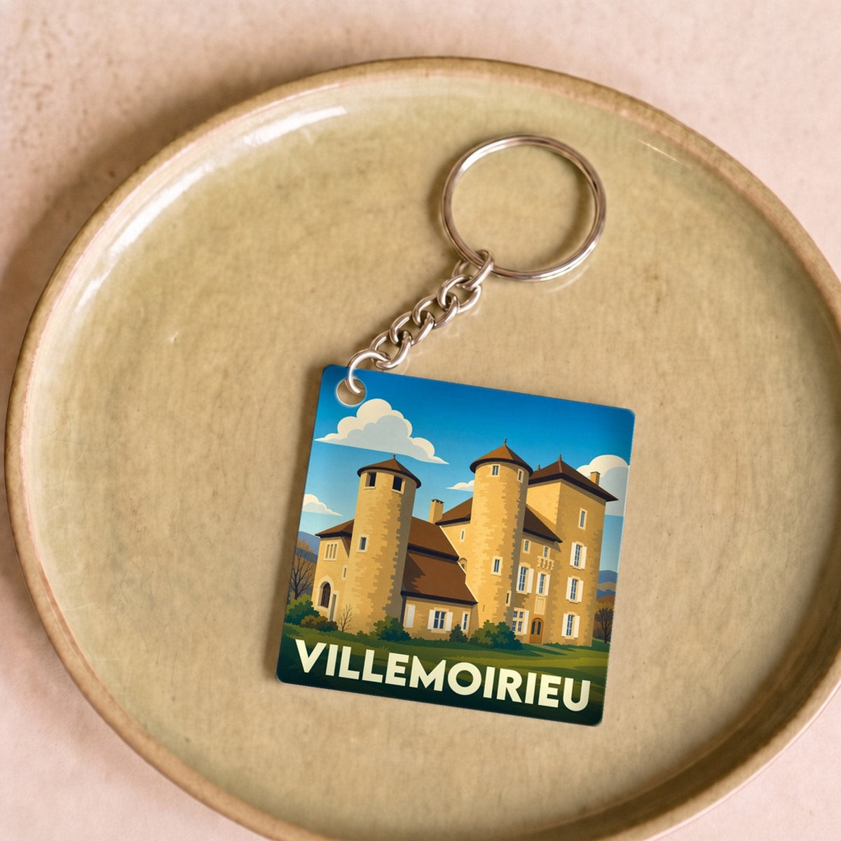 Porte-clés souvenir de la ville de Villemoirieu avec une illustration stylisée de son château.