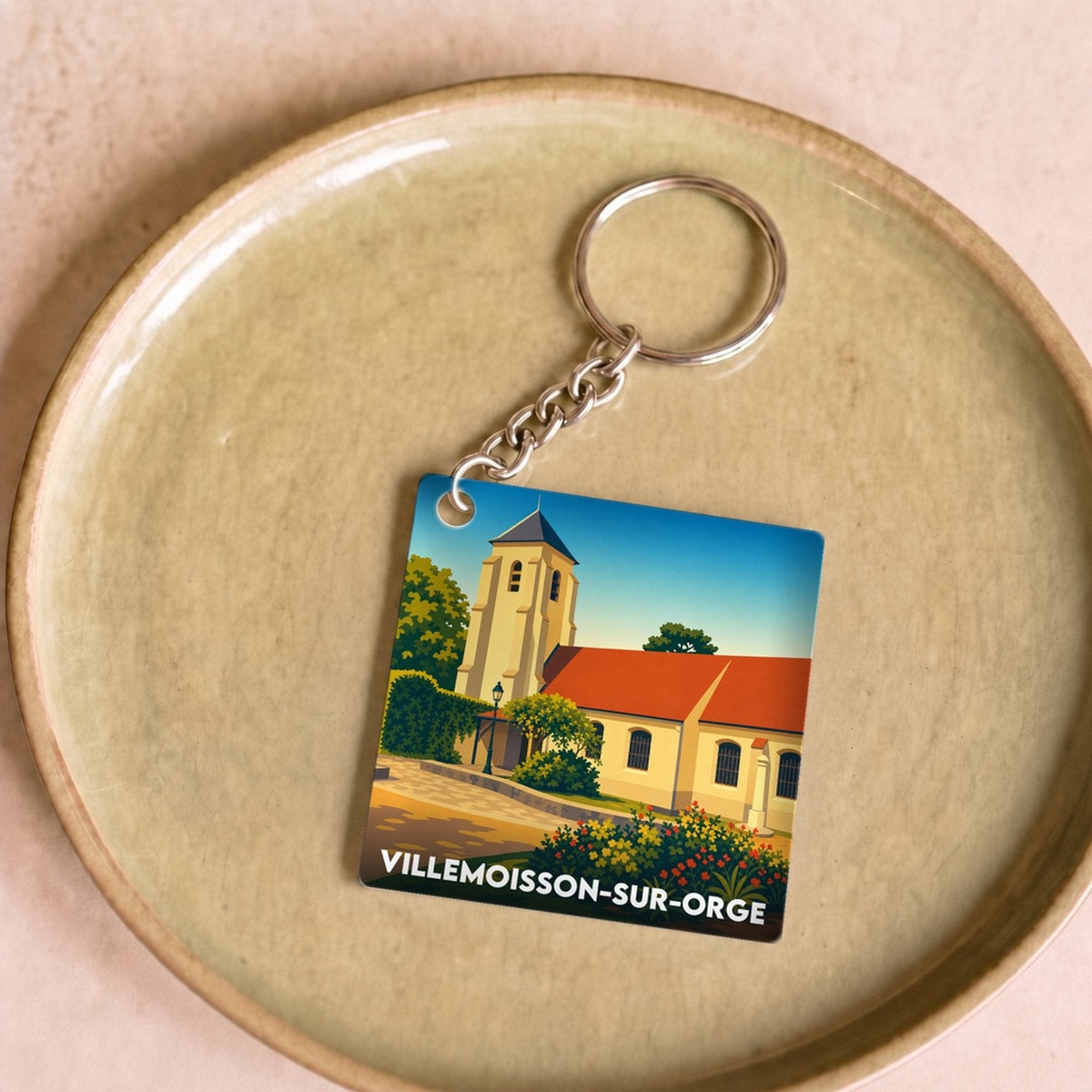 Porte-clés souvenir de la ville de Villemoisson-sur-Orge avec une illustration stylisée.