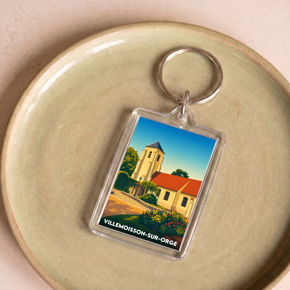 Porte-clés souvenir de la ville de Villemoisson-sur-Orge avec une illustration stylisée.