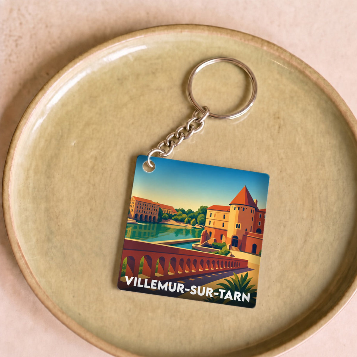 Porte-clés souvenir de la ville de Villemur-sur-Tarn avec une illustration stylisée.