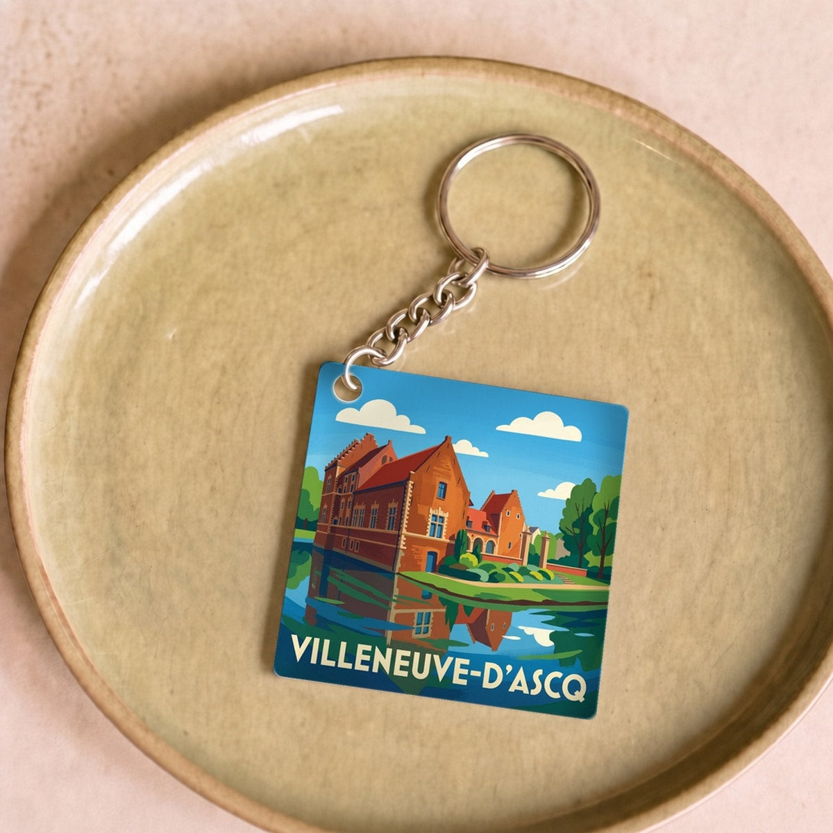 Porte-clés souvenir de la ville de Villeneuve-d'Ascq avec une illustration stylisée.