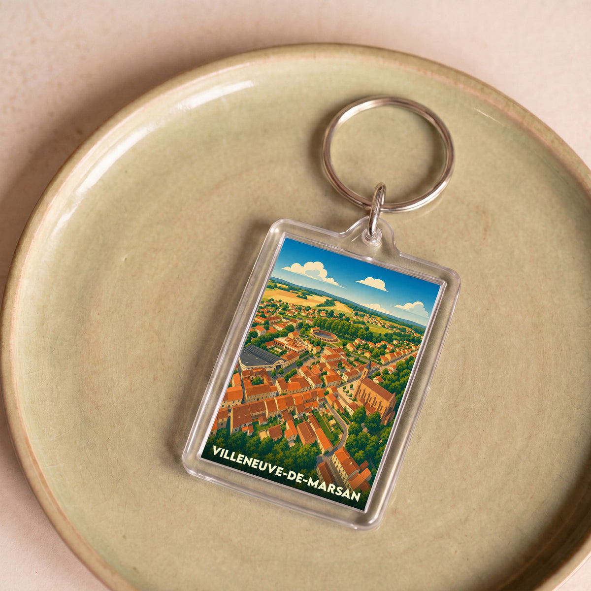 Porte-clés souvenir de la ville de Villeneuve-de-Marsan avec une illustration aérienne colorée et stylisée.