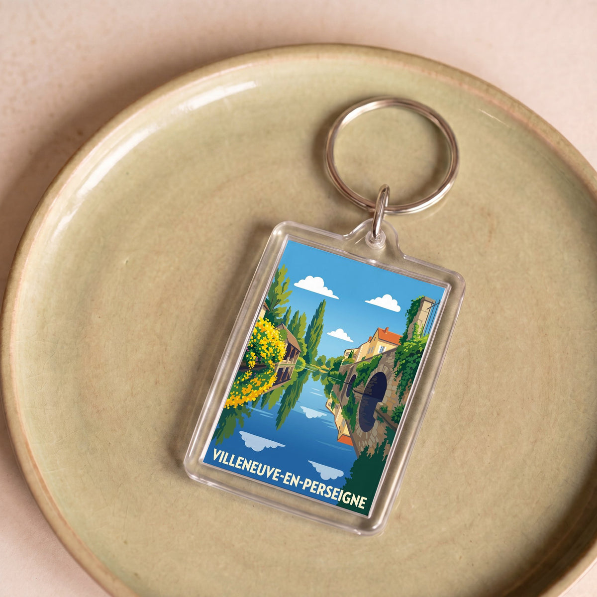 Porte-clés souvenir de la ville de Villeneuve-en-Perseigne avec une illustration stylisée.