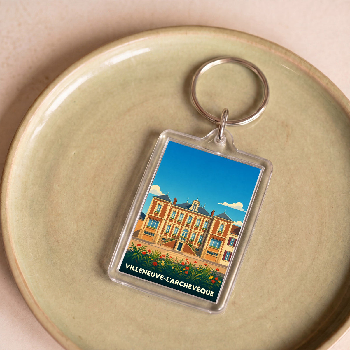 Porte-clés souvenir de la ville de Villeneuve-l'Archevêque avec une illustration stylisée.